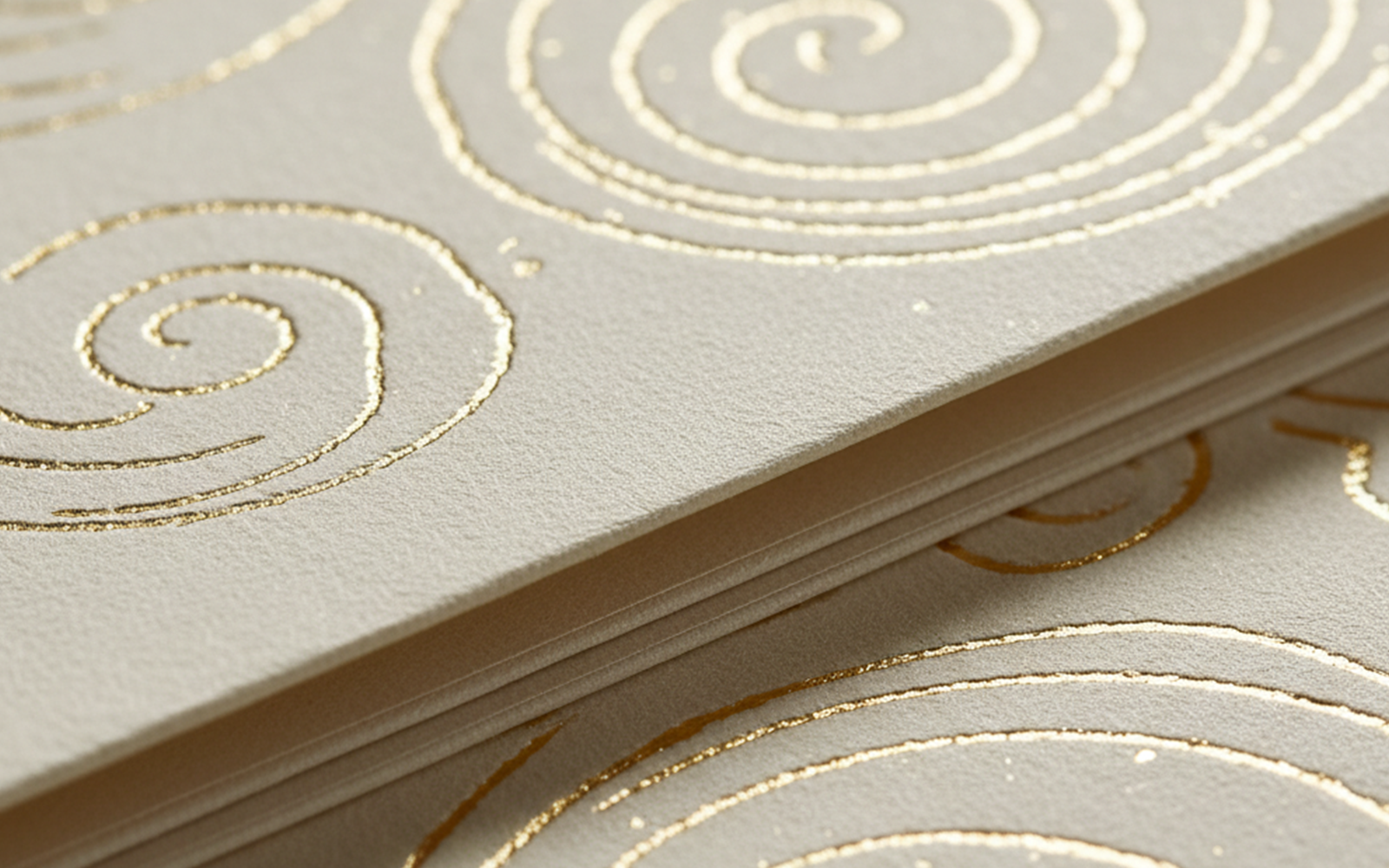 Close-up van premium gouden folieafwerkingen met cirkelvormige motieven op luxe wenskaarten
